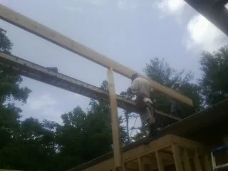 Carpenter setting a ridge beam over a new addition frame — Ice Dam Removal by Roofing Brothers in Russell